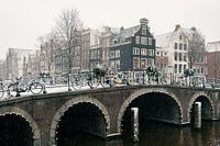 Brücke und Grachtenhäuser in Amsterdam im Schnee