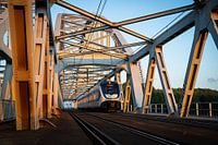 Een Sprinter trein rijdt over de spoorbrug tussen Weesp en Diemen