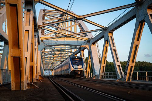 Een Sprinter trein rijdt over de spoorbrug tussen Weesp en Diemen