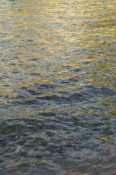Golden yellow light reflections in clear seawater by Adriana Mueller