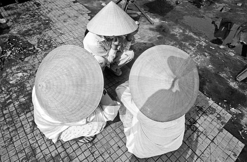 Vietnamese sun protection under a straw hat at the harbour in Hoi An