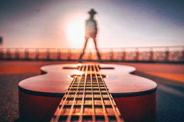 creative concept, guitar at sunset with model