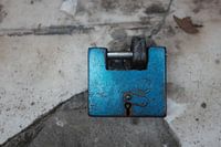 Blauw hangslot op verweerd marmer 