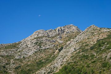 Mountain ridge and blue sky with moon by Adriana Mueller