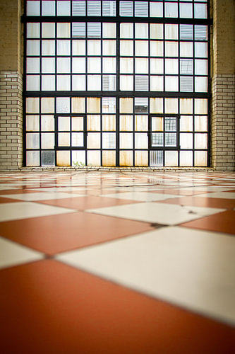 A window with lots of bars and a chequered floor in the foreground