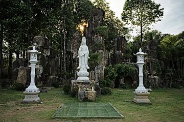 Bodhisattva statue in a sacred garden by Frank Photos
