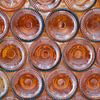 Oranje gekleurde, liggende wijnflessen van Melissa Peltenburg