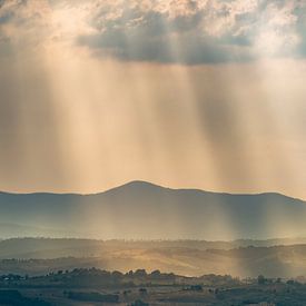 Lichtstralen over de heuvels in Toscane ... van Marc de IJk