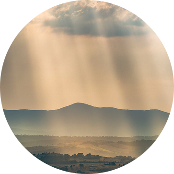 Lichtstralen over de heuvels in Toscane ... van Marc de IJk