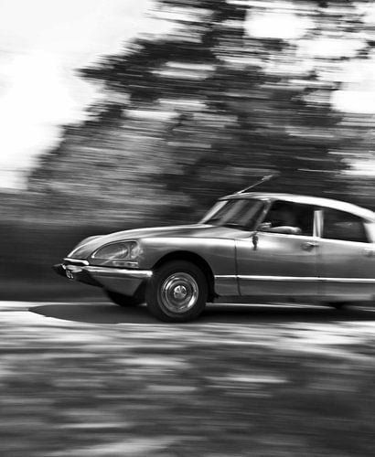 Picture of a driving Citroen DS in black and white.