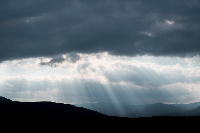 Himmlische Lichtstrahlen über den Bergen von Femke Ketelaar