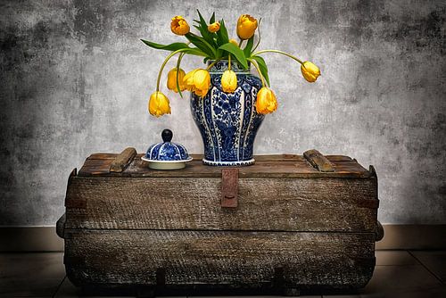 Delftsblauwe vaas met gele tulpen op vintage kist II