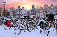 Besneeuwde fietsen in Amsterdam Nederland bij zonsondergang von Eye on You Miniaturansicht