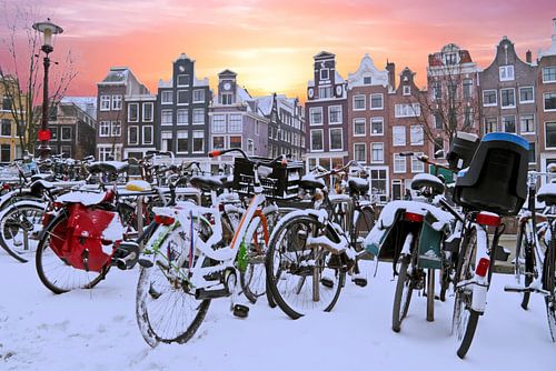 Besneeuwde fietsen in Amsterdam Nederland bij zonsondergang
