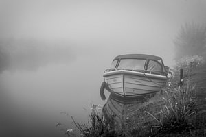 Bootje, wachtend in stilte op het optrekken van de mist