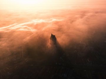 Martinikerk in Bolsward above fog at sunrise by Ewold Kooistra