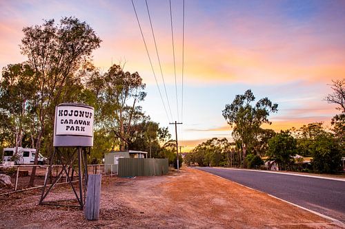 Australische Outback Straße bei Sonnenaufgang mit Eukalyptusbäumen