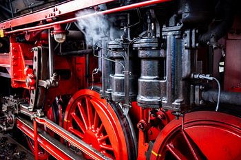Dampfige bewegliche Teile und Details der historischen Lokomotive mit roten Speichenrädern
