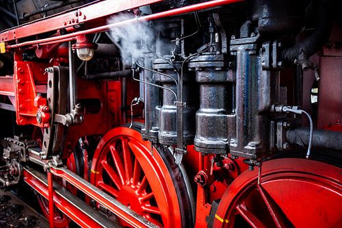 Dampfige bewegliche Teile und Details der historischen Lokomotive mit roten Speichenrädern