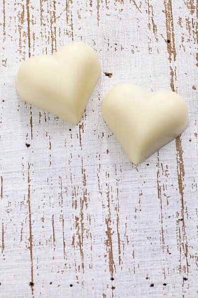 Twee witte chocolade harten op houten ondergrond van BeeldigBeeld Food & Lifestyle