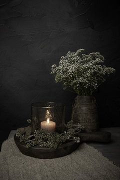 Atmosphärisches Stillleben mit Kerze im Windlicht und Gipskraut
