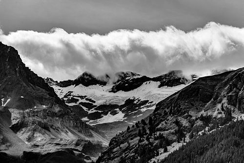Besneeuwde bergen in de wolken