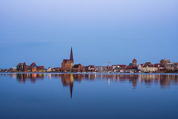 Uitzicht over de Warnow rivier naar de stad Rostock 's avonds van Rico Ködder