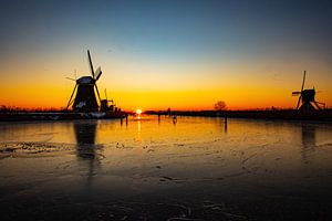 Kinderdijk im Winter mit Schlittschuhläufern und Sonnenaufgang