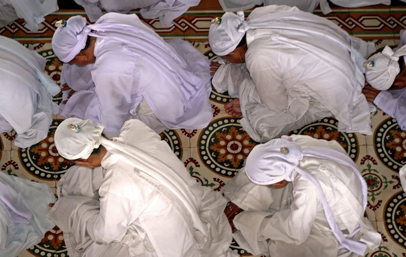 Praying in the Cao Dai temple by Gert-Jan Siesling