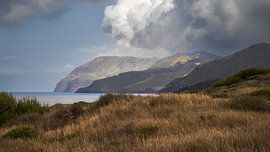 Une vue sereine sur la côte, avec une chaîne de montagnes majestueuse et la ligne d'horizon sur PhotoCluster