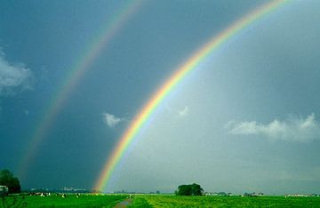Dubbele regenboog boven een weiland van Nature in Stock