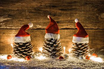 Funny Christmas time decoration with pine cones ornate with red santa hats, balls and shiny light