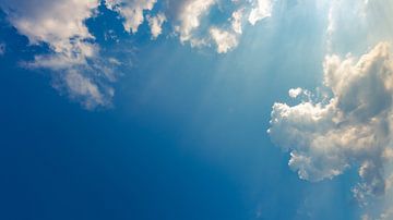 Blauer Himmel mit Wolken und Sonnenstrahlen von Robert Ruidl