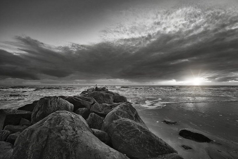 Large stones on the sandy beach at sunset in Denmark by Martin Köbsch