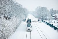 Ein Arriva-Zug in der verschneiten Landschaft bei Buitenpost