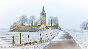 Oude kerktoren in winters landschap