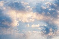 Wolkenformaties in blauw en geel aan een blauwe hemel