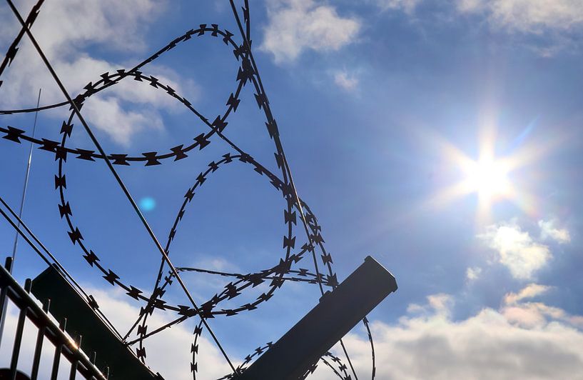 Close up of barbed wire on border fence by MPfoto71
