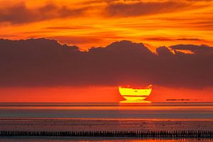 Achter de paaltjes - de zon zakt in de zee