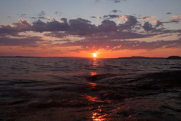 bright orange sunset over the waves scandinavia, karelia by Michael Semenov
