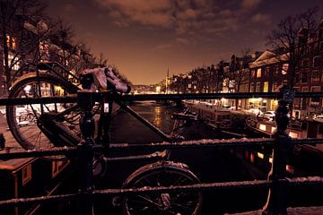 Fiets over een brug in Amsterdam Nederland bij nacht van Eye on You