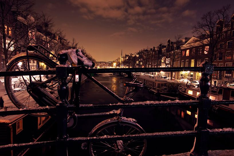 Fiets over een brug in Amsterdam Nederland bij nacht by Eye on You