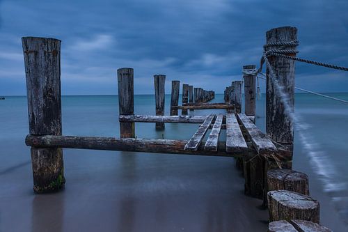 Verweerde houten steiger op het strand in Zingst