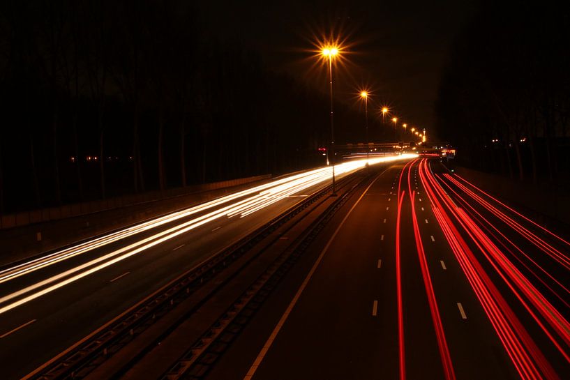 Lichtstrepen boven snelweg A20 van het verkeer in het donker von André Muller