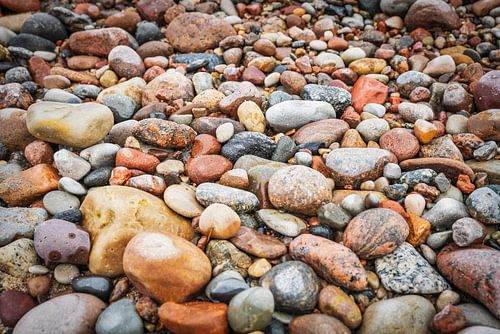 Veel kleurrijke stenen op het strand van de Oostzee