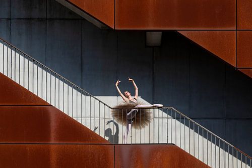 Die Pose einer Balletttänzerin auf der Treppe eines Gebäudes