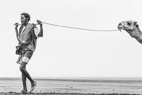 Man met zijn kameel onderweg naar een zoutmeer in Ethiopië