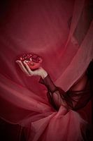 Virgin fruit, graceful arm holds pomegranate