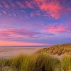 Phare sur l'île de Wadden Texel et un beau rouge du soir dans le ciel sur Rob Kints