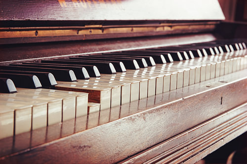 alte Vintage-Klaviertastatur, eine Taste wird gedrückt, Musikkonzept in warmen Farben im Retro-Stil 